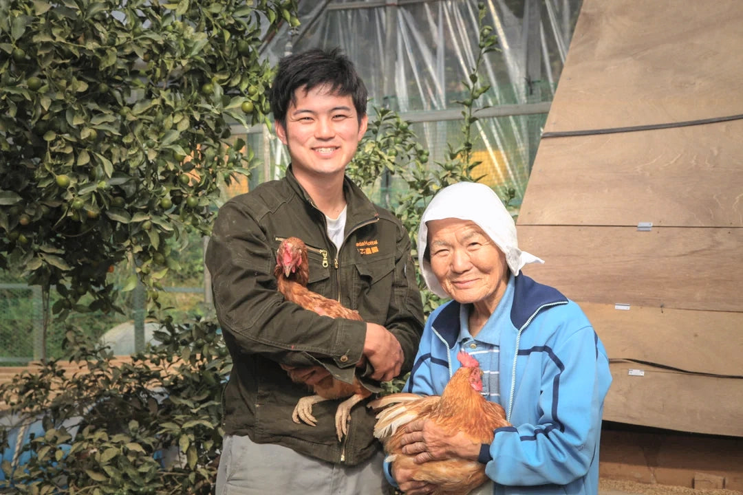 鶏を抱えて並ぶ、祖母・末子と作り手