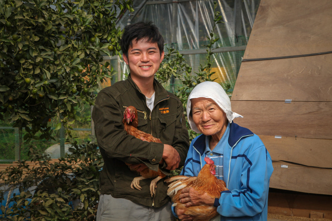 鶏を抱えて並ぶ、祖母・末子と作り手